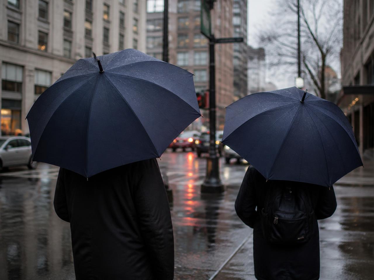 Deux parapluies unis ouverts sous la pluie en ville